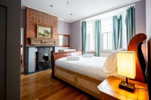 倫敦的住宿－Immaculate 4-Bed House in London，一间卧室设有一张大床和一个壁炉