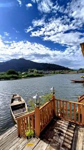 een houten steiger met een kleine boot op het water bij New Minar Group Of houseboats in Srinagar