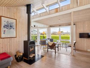 een woonkamer met een houtkachel en een tafel bij Holiday Home Wehrhart - all inclusive - 125m from the sea by Interhome in Otterup