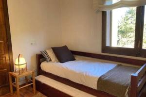 een kleine slaapkamer met een bed en een raam bij Apartament Pla del Roc in La Molina +7 foto's