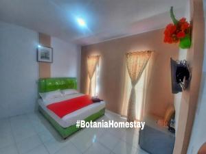 a small bedroom with a bed and a window at BOTANIA HOMESTAY BATAM in Nongsa