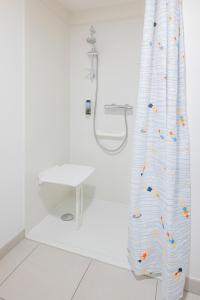 a shower in a bathroom with a shower curtain at All Suites Appart Hôtel - Le Havre Centre - Les docks in Le Havre