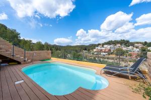 a swimming pool on top of a wooden deck with a chair at Vistabella in Tarragona