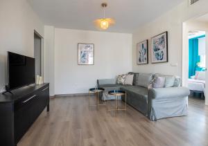 a living room with a couch and a flat screen tv at Renovado en el centro ascensor a la playa cerca in Torremolinos