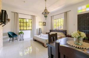 Palmhill Villa في بوراكاي: غرفة نوم بسرير وطاولة في غرفة