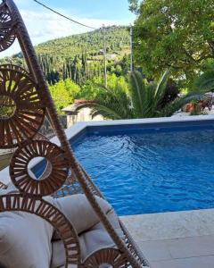 vista sulla piscina con sedia accanto di Villagio inn Suite & Spa a Soúlion