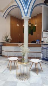 a lobby with a table and two chairs and a counter at Casa Palacio Don Pedro in Seville