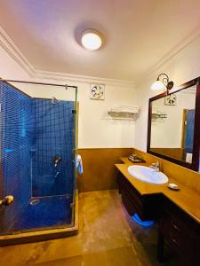 y baño con ducha y lavamanos. en MANVĀR SHERGARH, THE DESERT RESORT, en Shaitrāwa