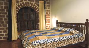 a bedroom with a bed and a brick wall at Verandah By The Sea in Vengurla +27 photos