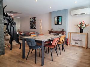 een woonkamer met een eettafel en stoelen bij L'Eau Vive Jacuzzi et Sauna en vieille ville 5 in Annecy