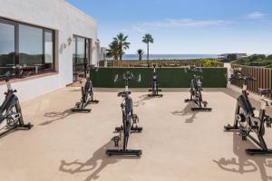 una fila de bicicletas estáticas estacionadas en un gimnasio en Sol Milanos Pingüinos, en Son Bou