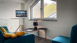 uma sala de estar com duas cadeiras azuis e uma televisão em ANDERSWELTENlodge em Stipshausen