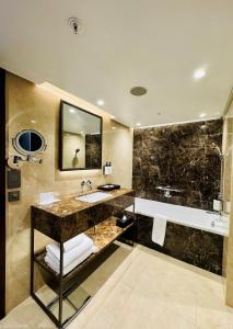 a bathroom with a large tub and a sink and a bath tub at InterContinental Lusaka, an IHG Hotel in Lusaka
