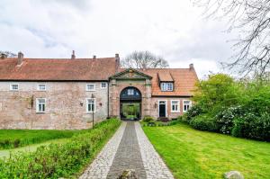 an old brick house with a pathway leading to it at Ferienwohnung Hausrosengarten in Hage