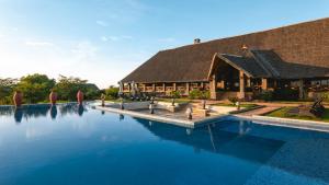 a resort with a swimming pool in front of a building at Lake Manyara Kilimamoja Lodge in Mto wa Mbu