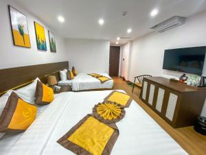 Giường trong phòng chung tại H&T Luxury Hotel