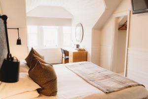 1 dormitorio con cama y escritorio con espejo en Hotel VARA en Truro