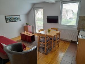 a living room with a table and chairs and a kitchen at Apartmani Nova Zova in Zlatibor