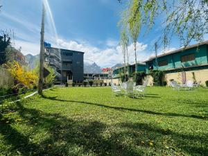 a group of lawn chairs in a yard with a building at Heaven Hotel Skardu in Skardu