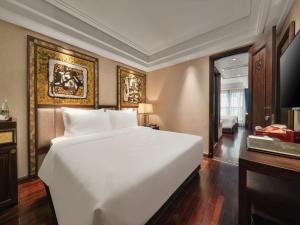 a bedroom with a large white bed in a room at Peridot Gallery Classic Hotel in Hanoi