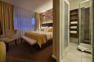 une chambre d'hôtel avec un lit et une chaise dans l'établissement Vysocina Design Apartments, à Hlinsko
