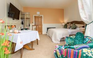 グレンジ・オーバー・サンズにあるGrange Manorのベッドルーム1室(ベッド2台、テーブル、ソファ付)