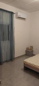een lege kamer met een bed en een gordijn bij Lola Appartements 1 in Kribi