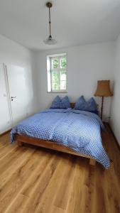 1 dormitorio con cama con sábanas azules y ventana en Rittergut Thürungen, en Kelbra