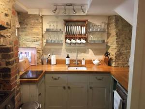 a kitchen with a sink and a counter top at Wishbone Cottage In The Cotswolds in Fairford