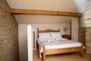 a bedroom with a bed with two teddy bears on it at Wishbone Cottage In The Cotswolds in Fairford