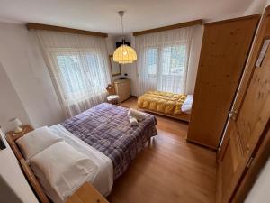ein kleines Schlafzimmer mit einem Bett und einem bedruckten Schlafzimmer in der Unterkunft B&B Meublè Giustina in Auronzo di Cadore