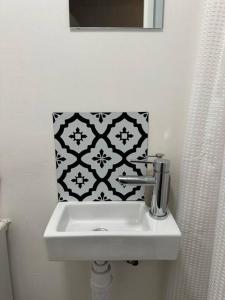 ein Badezimmer mit Waschbecken und schwarz-weißen Fliesen in der Unterkunft Garden Apartment with free Parking and EV in Bristol + 4 Fotos