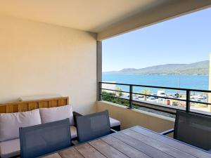 Habitación con mesa, sillas y vistas al agua. en Fronte di Mare 2 chambres vue mer - 1 en Propriano