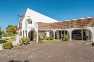 un edificio de ladrillo con una entrada de ladrillo delante de él en Riverside Motel, en Whanganui