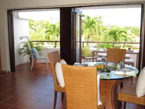 comedor con mesa y sillas en el balcón en Holiday Home at Rio Mar, en Río Grande