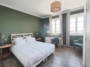 a bedroom with a large white bed and a desk at L'Art des Mets by Côté Jardin in Conilhac-Corbières
