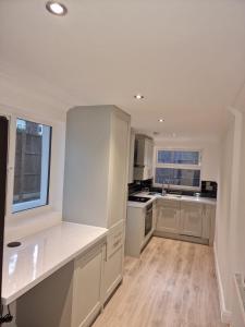 uma cozinha com armários brancos e uma bancada em 2Philipot em Eltham