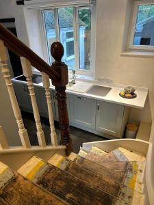 a kitchen with a staircase with a sink and a counter at Waterside Victorian house at Golant Fowey in Fowey