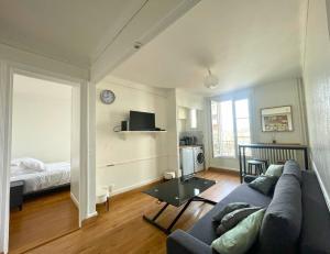 ein Wohnzimmer mit einem Sofa und einem Tisch in der Unterkunft 15 min from the Eiffel Tower - Charming apartment in Issy-les-Moulineaux
