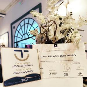 a sign and a vase with white flowers at Casa Palacio Don Pedro in Seville