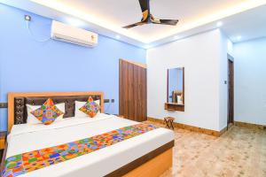 a bedroom with a bed and a ceiling fan at FabHotel D Park in kolkata +24 photos