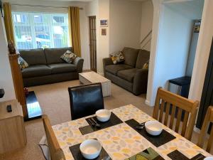 uma sala de estar com uma mesa e um sofá em Paignton View Holiday Home em Paignton