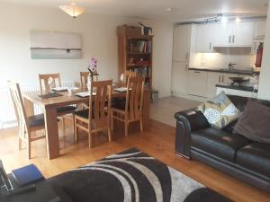 uma sala de estar com um sofá, uma mesa e uma cozinha em Cosy home in an area of outstanding natural beauty em Wookey Hole
