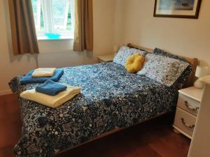 um quarto com uma cama com lençóis e almofadas azuis em Cosy home in an area of outstanding natural beauty em Wookey Hole