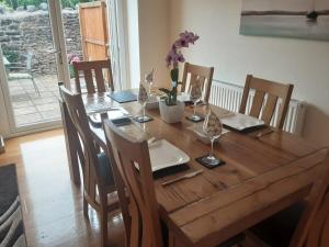 una mesa de madera con sillas y una mesa de madera con flores. en Cosy home in an area of outstanding natural beauty, en Wookey Hole