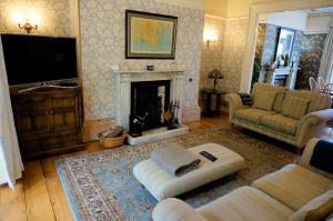 Una sala de estar con un sofá y una chimenea. en Spacious Town House with Swimming Pool, en Plymouth