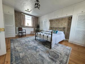 un dormitorio con una cama y una alfombra en Spacious Town House with Swimming Pool, en Plymouth