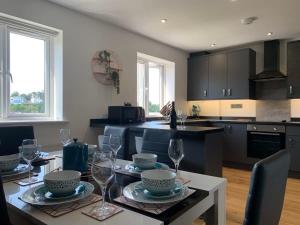 a kitchen with a table with wine glasses on it at The Mariners' Beacon Torquay in Torquay