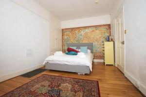 1 dormitorio con 1 cama y una pared con un mural en Spacious Town House with Swimming Pool, en Plymouth 12 fotos más