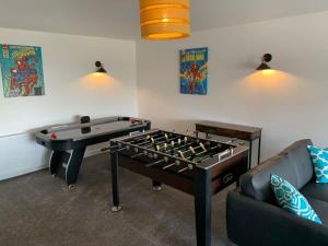 a living room with a foosball table and a couch at The Mariners' Beacon Torquay in Torquay
